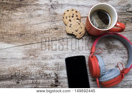 Red coffee cup Red headphone and chocolate chip cookies on the wooden table. View from above. Coffee with chirstmas concept.
