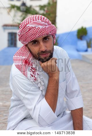 Young smiling handsome arabic man wearing traditional clothes