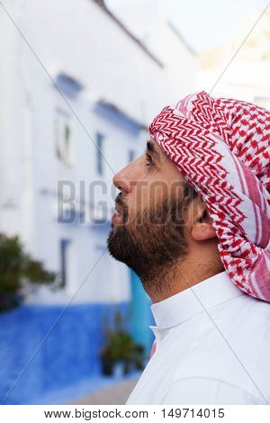 Young smiling handsome arabic man wearing traditional clothes