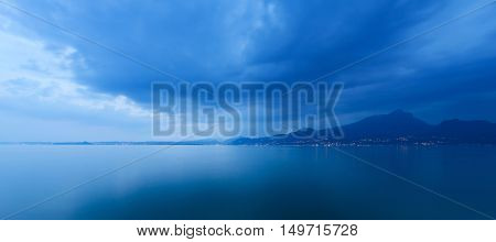 Lago di Garda in the evening (Garda Lake) the largest Italian lake of glacial origin with the lights of the coast of Lombardy Italy