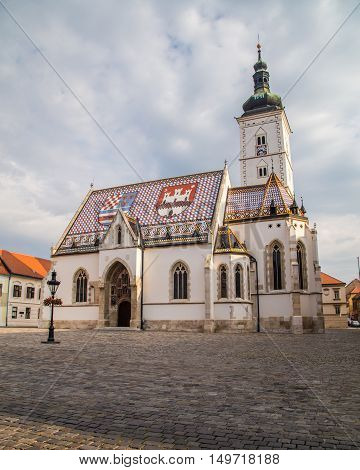 ZAGREB CROATIA - 17TH AUGUST 2016: The outside of St Marks Church in central Zagreb Croatia during the day. A person can be seen.