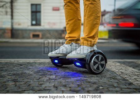 man is using hoverboard against the background of leaving car