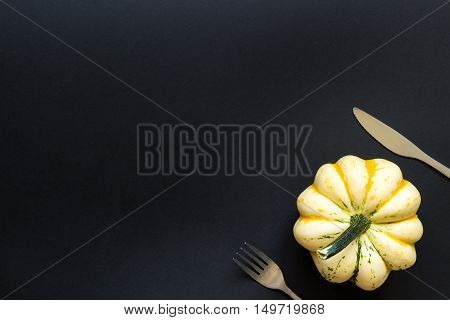 Decorative Pumpkin And Cutlery On The Black Table