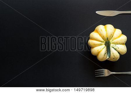 Decorative Pumpkin And Cutlery On The Black Table