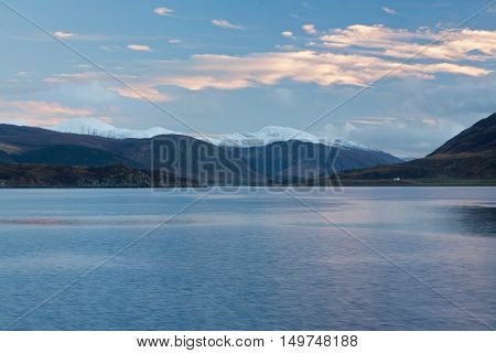 Snowcapped mountains by the sea at Ullapool Scotland