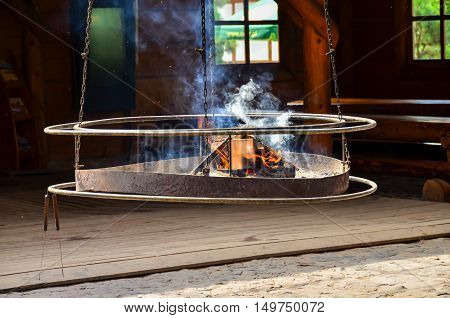 Image of a hanging grill with the fire ready for barbecue
