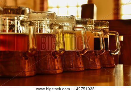 Five glasses different taste of beer stand in a row on the bar table. Shallow D.O.F.
