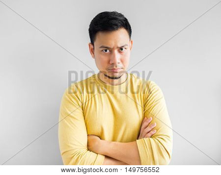 Asian man in yellown shirt seriously thinking Asian man crossed arm.