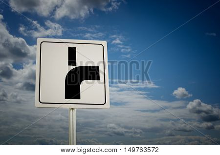 Road sign with cloudy sky background. Main road bends to the right.