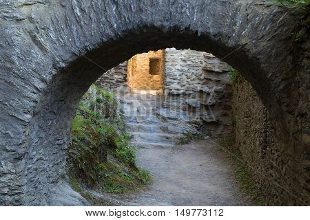 Stone corridor in the ruins of ancient castle. Fragment of fortress wall with arched entrance . Interior courtyard. Castle in Rhine Valley. Germany