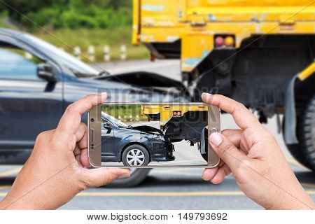 Close up hand of woman holding smartphone and take photo of car accident