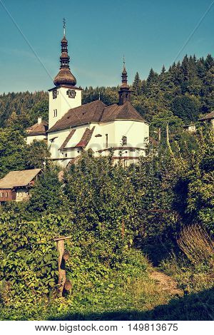 Fortified church in Spania Dolina Slovak republic. Travel destination. Blue photo filter. Religious architecture. Beautiful place. Vertical composition.