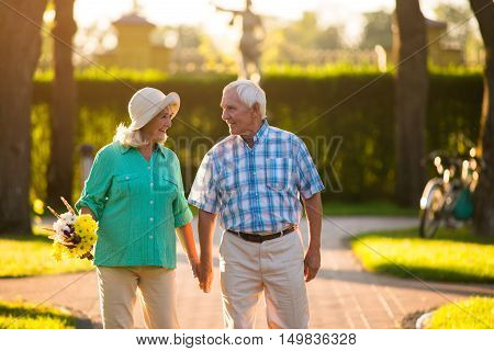 Senior couple is holding hands. Man and woman outdoor. Unity and happiness. Feelings are priceless.