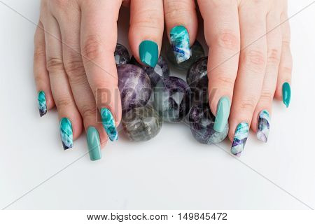 Closeup of woman nails with creative purple and green manicure. Fluorinit print. Copy space.