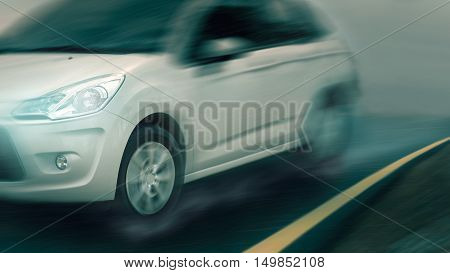 Fast moving white car at rainy day on wet asphalt road in motion blur. Speed concept.