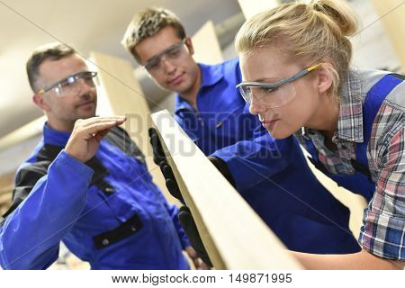 Carpenter with apprentice in workshop