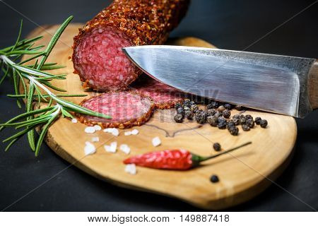 Dried Salami Crusted In Ground Red Pepper On Dark Background