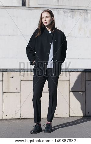 young female fashion model in black bomber jacket gray shirt and black boots - street style