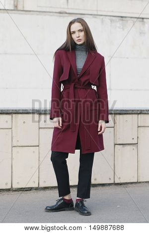 young stylish woman in classic red trench coat melange blouse and black shoes - street fashion