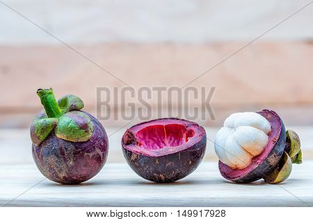Mangosteen fruit on the ground. Peeled for white meat inside.