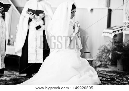 Virgin young bride pray at church at wedding