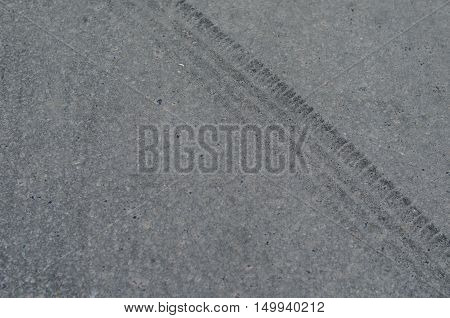 Traces of wheel tires on gray asphalt road