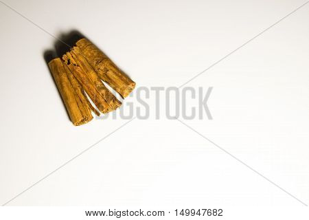 Three sticks of cinnamon in a white background
