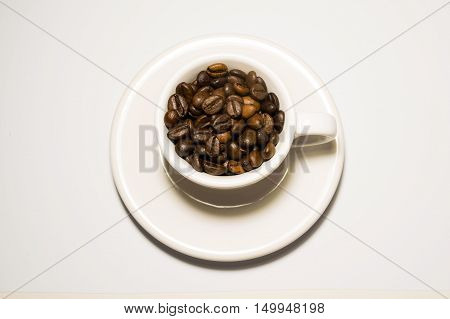 Coffee cup full of beans on a white background