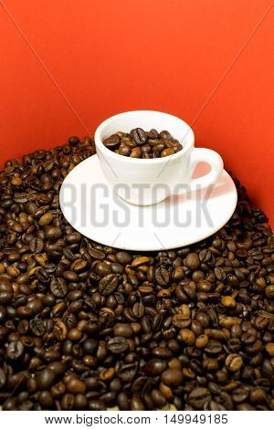 A coffee cup full of beans in a red background