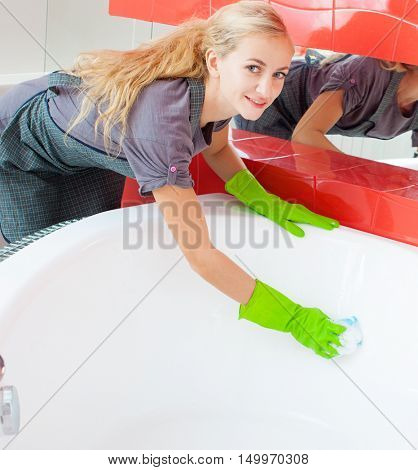 Woman cleaning bath at home. Female washing bathtub. Tub