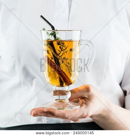 The Unidentified Waiter Holding A Glass With Hot  Amaro Cocktail With Apple Juice And Cinnamon