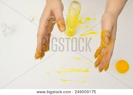 How To Make Slime. A Female Hands Holds Yellow Homemade Slime Is A Children's Toy Close Up. Composit