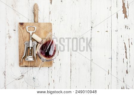Wine Degustation Concept -  Red  Wine  Glass, Wine Corks  And Corkscrew On White Wooden Table With C
