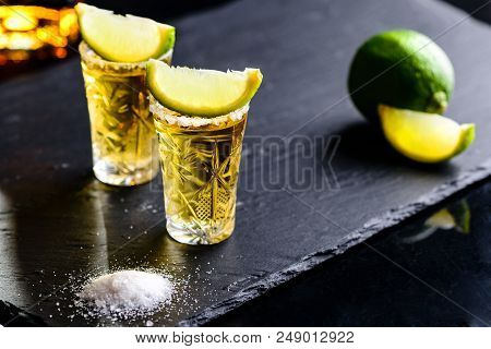 Gold Mexican Tequila With Lime And Salt On Dark Table