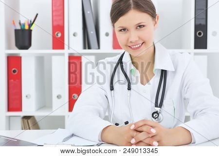 Yount Female Smiling Therapist Talks To The Patient.