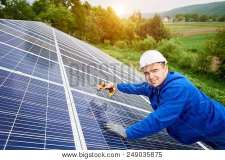 Construction Worker Connects Photo Voltaic Panel To Solar System Using Screwdriver. Professional Ins