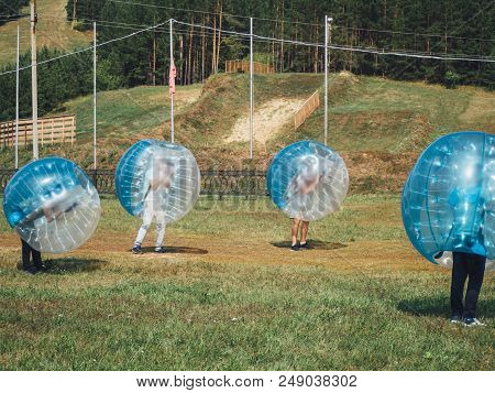 People Play Bumperball Zorbsoccer Outdoor. Summer Time