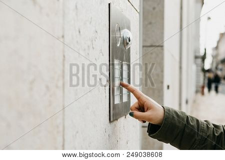 Close Up The Female Hand Presses The Doorphone Button. The Girl Is Calling The Intercom.