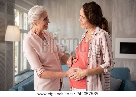 Talking To Aunt. Good-looking Smiling Broadly Expecting Woman Feeling Entertained While Talking To H