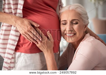 Nude Makeup. Mature Woman With Nice Nude Makeup Smiling Broadly While Putting Her Ear Near Pregnant 