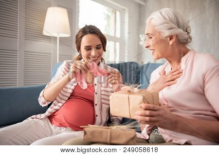 Pink Socks. Loving Mother Feeling Unbelievably Memorable While Presenting Little Pink Socks To Pregn