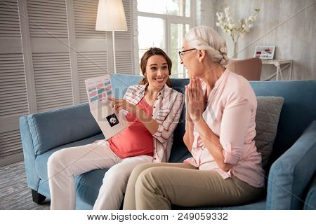 Positive Results. Smiling Excited Mother Feeling Rather Enthusiastic While Looking At Medical Result