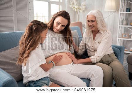Stylish Clothes. Three Women Of Different Generations Wearing Nice Stylish Light Clothes While Sitti