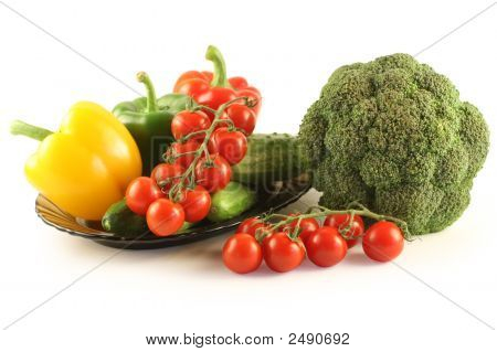 Brokolice, okurky, paprika a rajčata na desku na bílém pozadí