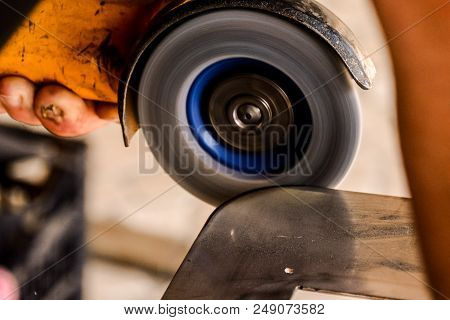 Heavy Industry Worker Cutting Steel With Angle Grinder At Car Service