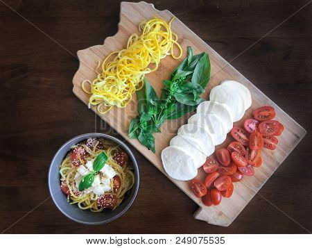 Caprese Zoodles Salad And Ingredients On Dark Wood Table
