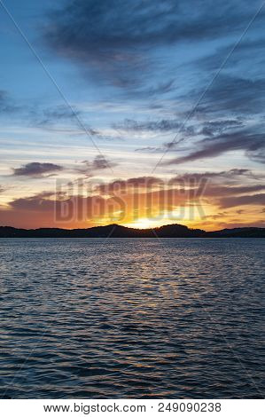 A Delightful Inspirational Multi-colored Cloudy Sunrise Seascape Over Sea Water With Water Reflectio