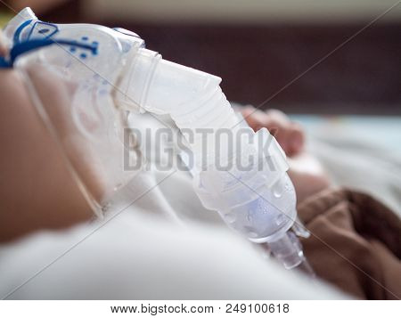 Close Up Asia Boy Making Inhalation With Nebulizer Mask At The Hospital