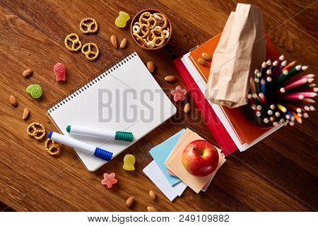 A Notebook, Two Markers And Banana In Plastic Lunchbox On A Wooden Table, Copy Space For Text, Selec
