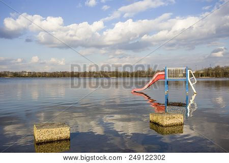 Water Slide In A Lake In The Netherlands In The Summer , Playground For Children With Blue Sky